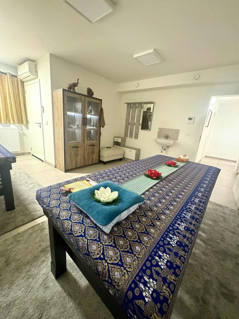 Massagetafel met Thais brocaat en verse bloemen in de salon van Songkran